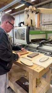 Koulutuskeskus Salpauksen lehtori Timo Poskela esittelee CNC-työstökeskuksella tehtäviä oppilastöitä.